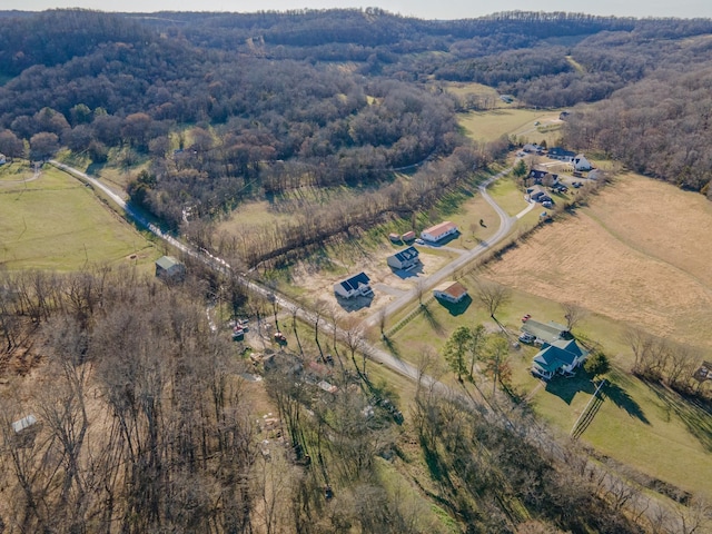 drone / aerial view with a wooded view and a rural view