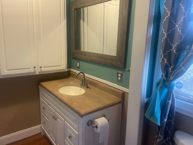 bathroom featuring hardwood / wood-style floors, vanity, and toilet