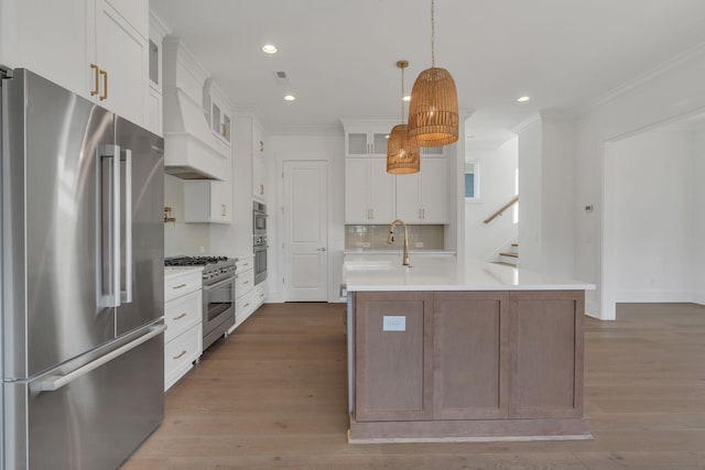 kitchen with dark wood-style floors, high quality appliances, ornamental molding, custom exhaust hood, and light countertops