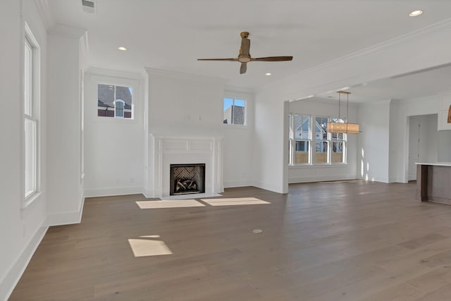 unfurnished living room featuring a fireplace with flush hearth, visible vents, wood finished floors, and ornamental molding