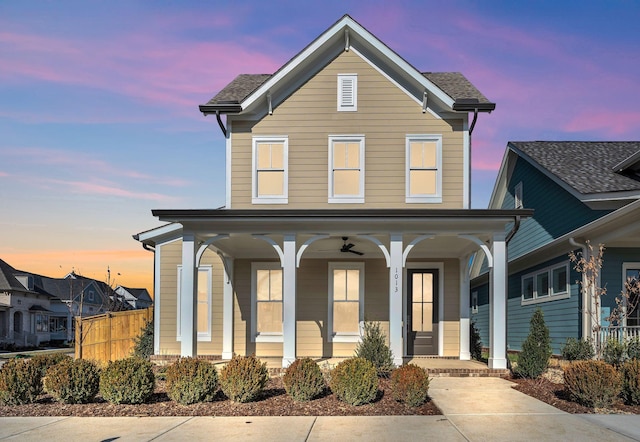 traditional-style house with a porch and fence