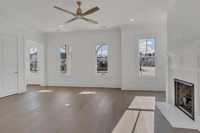 unfurnished living room featuring a fireplace, crown molding, visible vents, wood finished floors, and baseboards