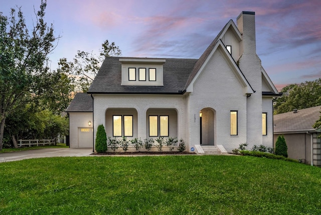 view of front of property with a garage and a yard