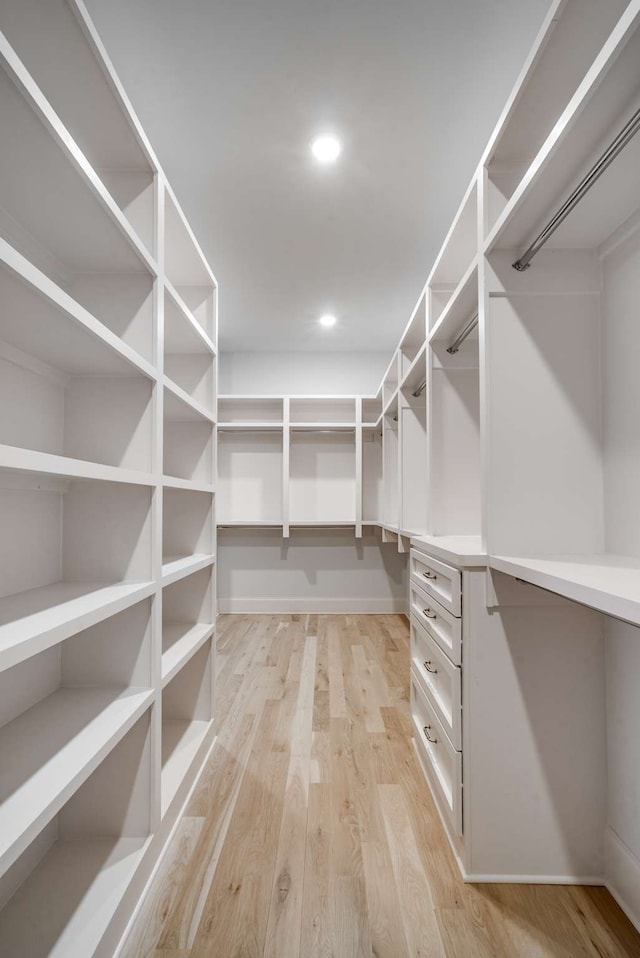 walk in closet with light hardwood / wood-style floors