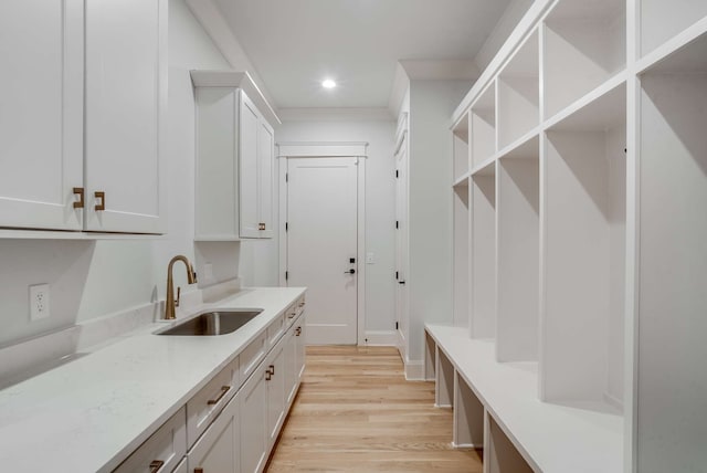 mudroom with light hardwood / wood-style floors and sink