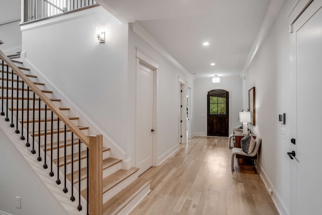 entrance foyer with light hardwood / wood-style floors and crown molding