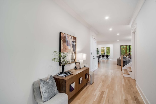 hallway featuring light wood-type flooring and crown molding