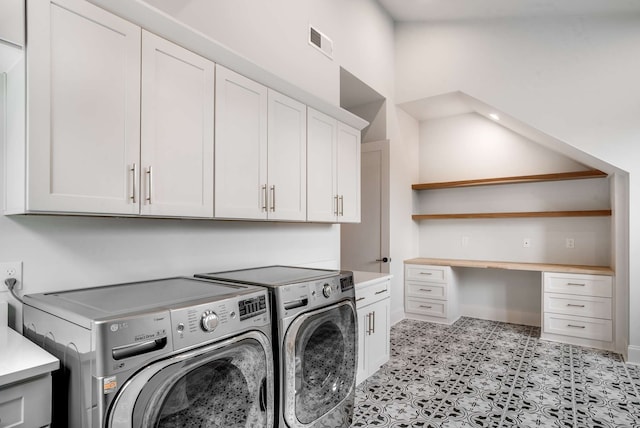 clothes washing area featuring cabinets and washing machine and dryer