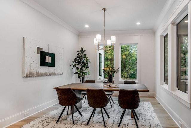 dining space with light hardwood / wood-style flooring and a notable chandelier