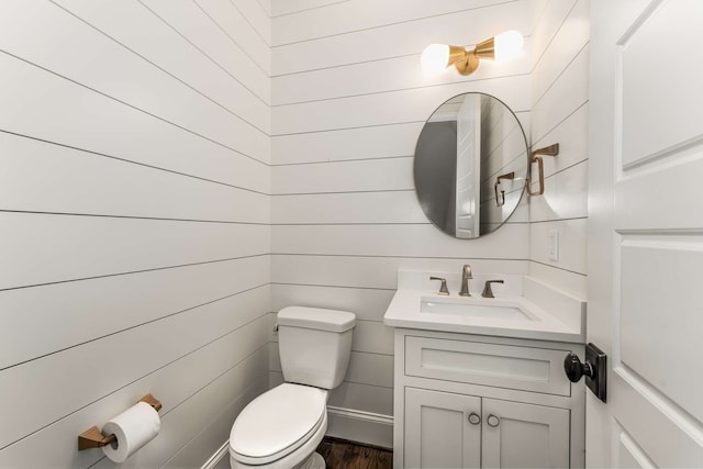 bathroom with wood-type flooring, vanity, and toilet