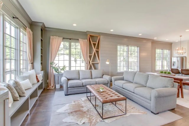 living room with ornamental molding, a chandelier, and hardwood / wood-style flooring