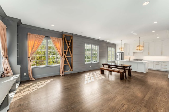 game room with dark hardwood / wood-style floors, crown molding, and a wealth of natural light