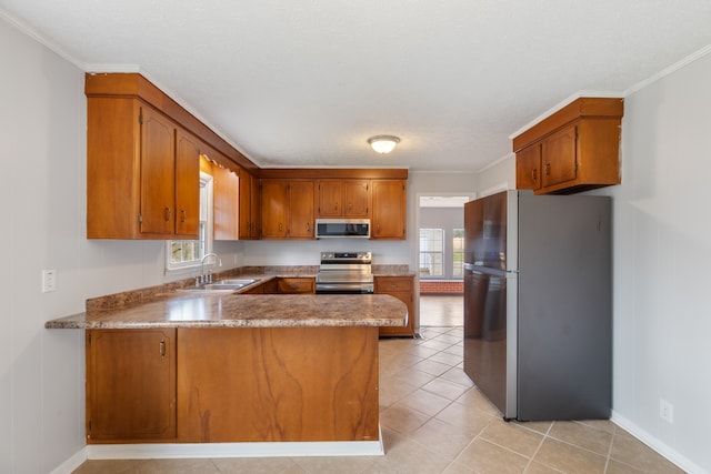 kitchen featuring kitchen peninsula, ornamental molding, sink, and stainless steel appliances