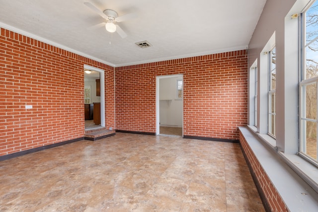 unfurnished sunroom featuring ceiling fan