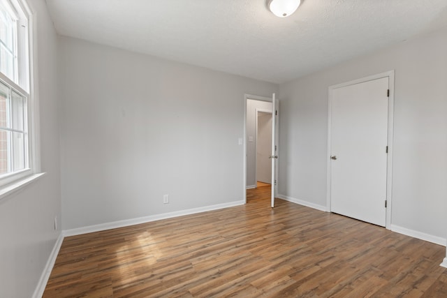 unfurnished bedroom featuring hardwood / wood-style flooring and a textured ceiling