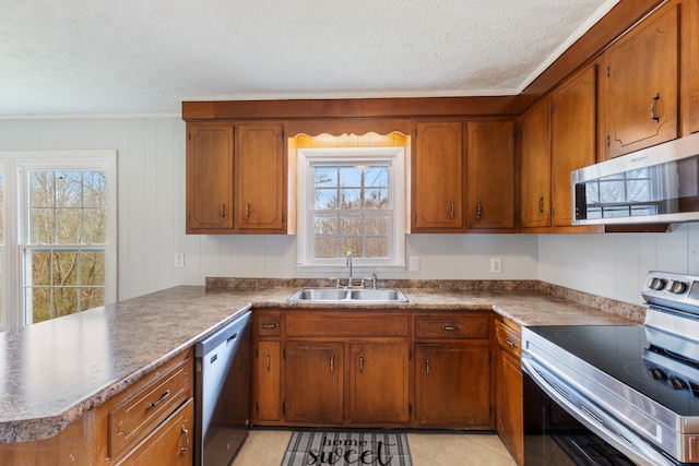 kitchen featuring stainless steel appliances, plenty of natural light, sink, and kitchen peninsula