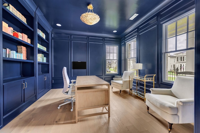 office area with built in shelves and hardwood / wood-style flooring