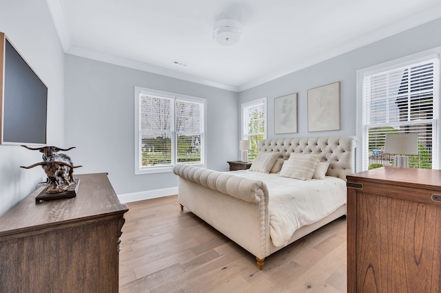 bedroom featuring ornamental molding and light wood-type flooring