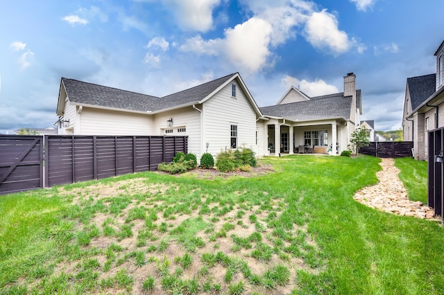 rear view of property with a yard and a patio area