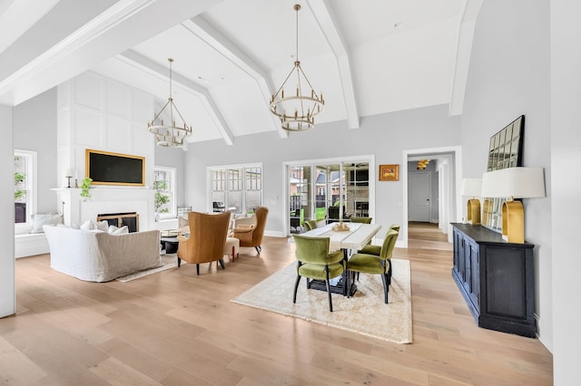 dining space featuring light wood-type flooring, beam ceiling, and high vaulted ceiling