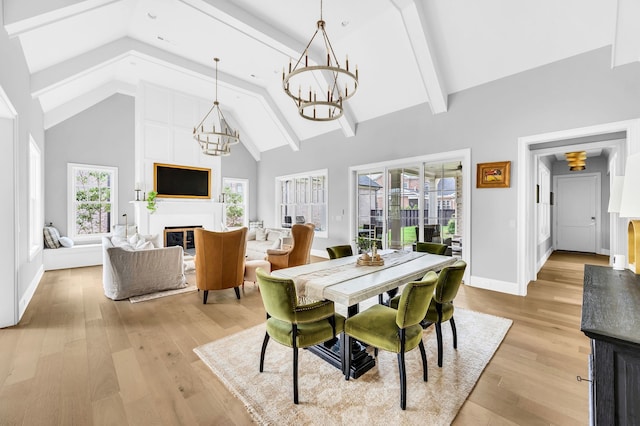 dining space featuring light wood-type flooring, beamed ceiling, and high vaulted ceiling