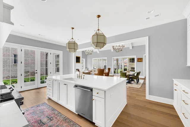 kitchen with dishwasher, light hardwood / wood-style floors, sink, white cabinetry, and decorative light fixtures