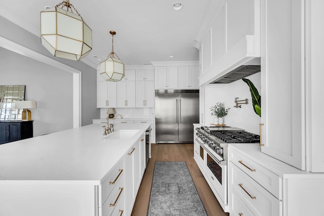 kitchen featuring hanging light fixtures, white cabinets, high quality appliances, a kitchen island with sink, and dark hardwood / wood-style floors