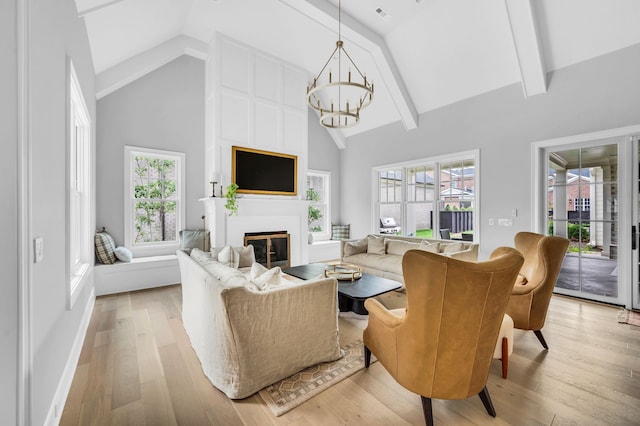 living room with light wood-type flooring, an inviting chandelier, beamed ceiling, and high vaulted ceiling