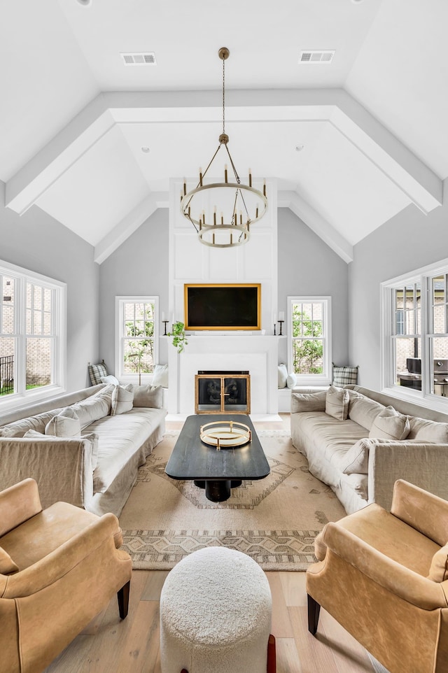 living room with an inviting chandelier, a large fireplace, hardwood / wood-style floors, and a wealth of natural light