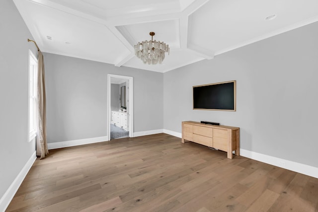 unfurnished living room featuring wood-type flooring, beamed ceiling, a notable chandelier, and ornamental molding