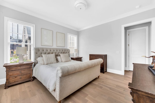 bedroom featuring ornamental molding, light hardwood / wood-style floors, and multiple windows