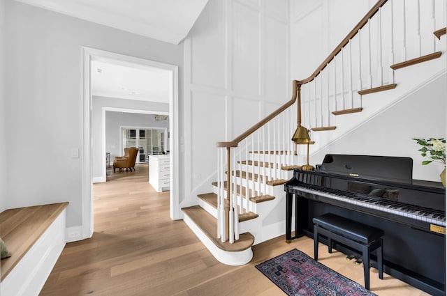 foyer entrance with light wood-type flooring and ornamental molding