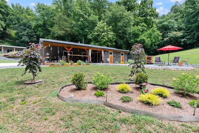 ranch-style home featuring a front lawn, a patio area, and an outdoor fire pit