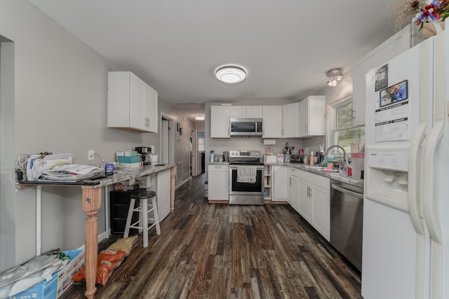 kitchen featuring stainless steel appliances, white cabinets, dark hardwood / wood-style floors, and sink