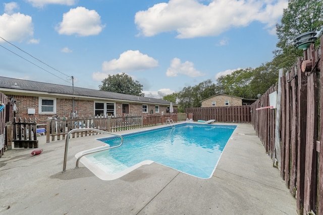 view of pool featuring a patio area and a diving board