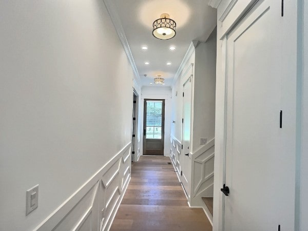 hallway with ornamental molding and dark wood-type flooring