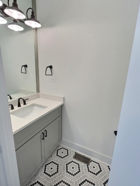 bathroom featuring tile patterned floors, a chandelier, and vanity