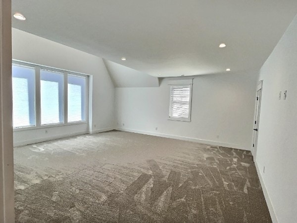 empty room with dark carpet and lofted ceiling