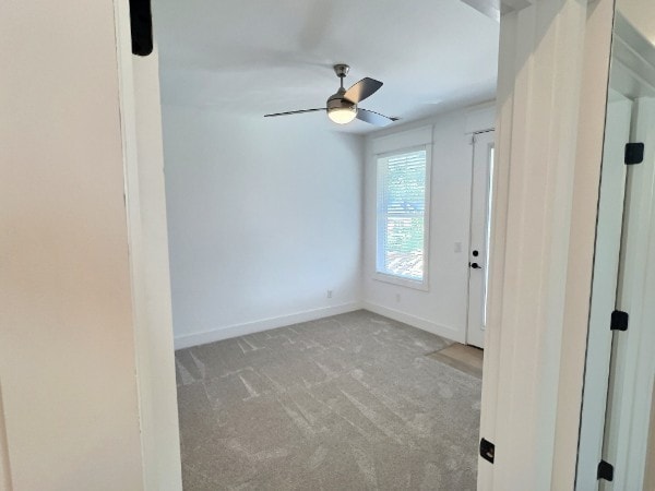 carpeted empty room featuring ceiling fan