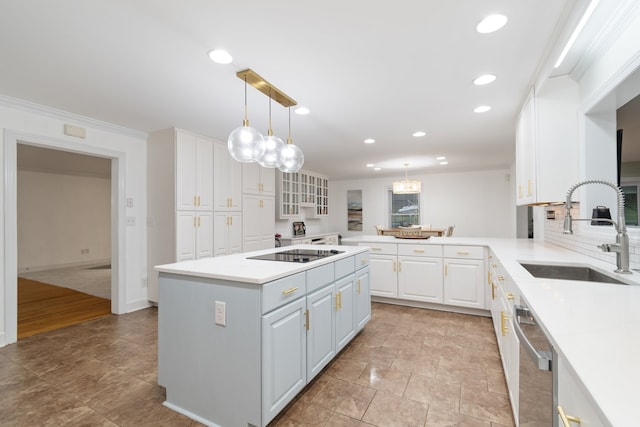 kitchen featuring pendant lighting, black electric stovetop, sink, ornamental molding, and white cabinetry