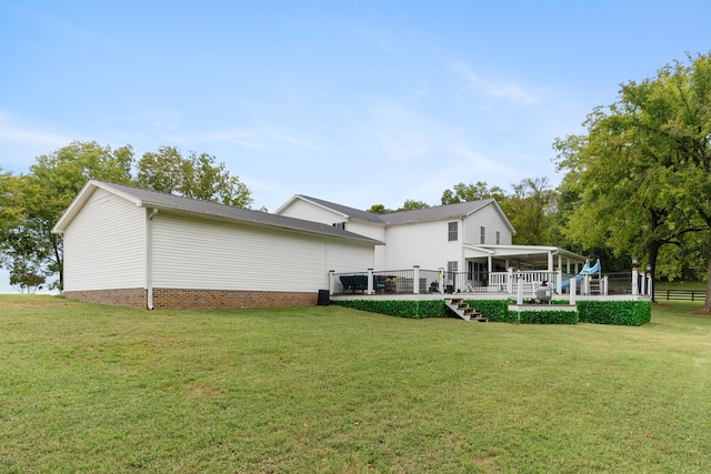 rear view of house featuring a yard and a wooden deck