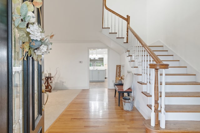 foyer with light carpet and a towering ceiling