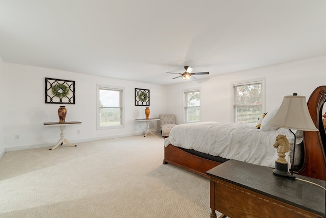 carpeted bedroom featuring multiple windows and ceiling fan