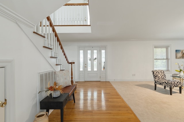 foyer featuring a wealth of natural light, hardwood / wood-style floors, and ornamental molding