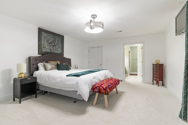 bedroom with connected bathroom and light colored carpet