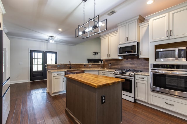 kitchen featuring butcher block countertops, pendant lighting, stainless steel appliances, a center island, and dark hardwood / wood-style floors