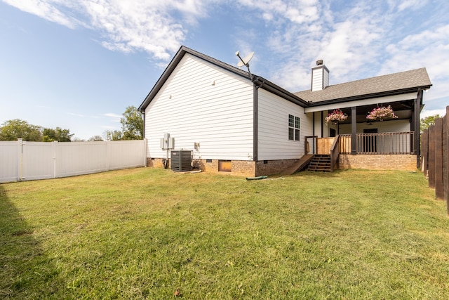 back of house with a lawn and central air condition unit