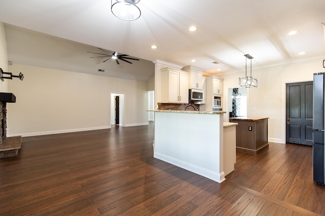 kitchen featuring light stone countertops, appliances with stainless steel finishes, dark hardwood / wood-style floors, and crown molding