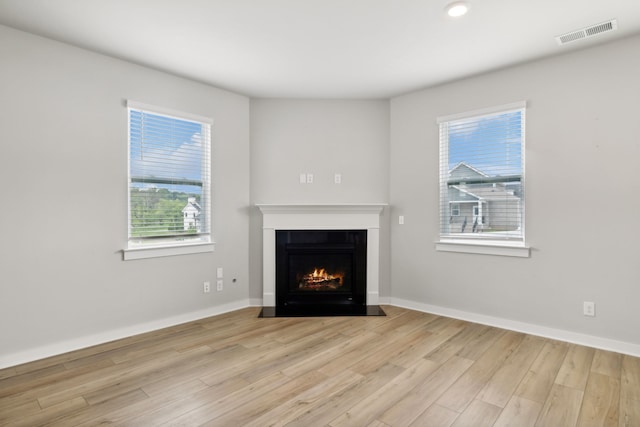 unfurnished living room featuring light hardwood / wood-style flooring and a wealth of natural light