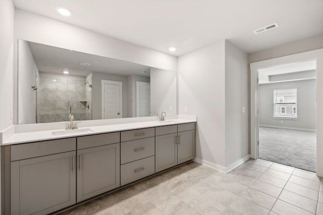 bathroom featuring vanity, tile patterned floors, and tiled shower